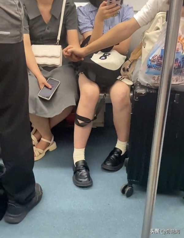 情侣地铁上隔人坐仍手拉手!不尴尬吗